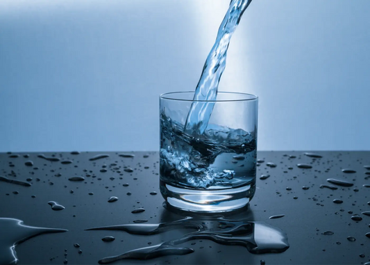 verre d'eau transparent sur une table avec des gouttes