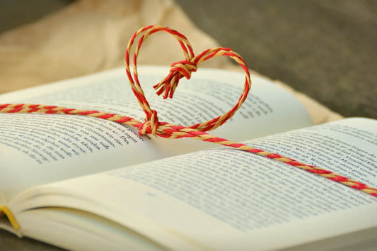 livre de poésie ouvert avec un cordon en tissu rouge et jaune en forme de coeur 